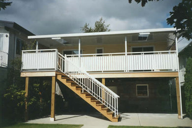 Diseño de terraza de tamaño medio en patio trasero y anexo de casas