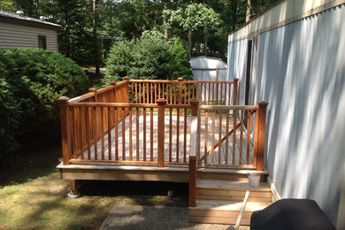 Mid-sized elegant side yard deck photo in New York with no cover