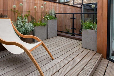 Modelo de terraza moderna pequeña sin cubierta en patio lateral con jardín de macetas