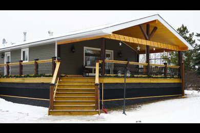 Example of a mid-sized mountain style backyard deck design in Edmonton with a roof extension