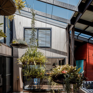 Design ideas for a beach style courtyard deck in Gold Coast - Tweed with a pergola.