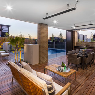 Contemporary backyard deck in Canberra - Queanbeyan with an outdoor kitchen and a roof extension.