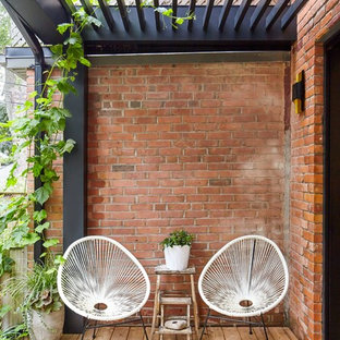 Foto de terraza nórdica, pequeña, en patio trasero, con jardín de macetas y pérgola