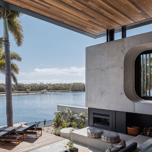 Photo of a contemporary backyard deck in Gold Coast - Tweed with with fireplace and a roof extension.