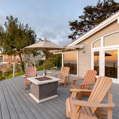 Huge beach style backyard deck photo in Los Angeles with a fire pit and no cover