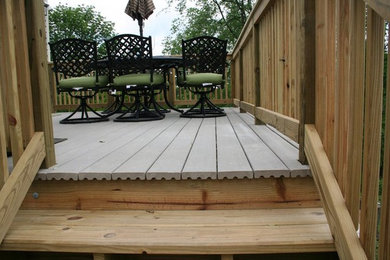 Example of a mid-sized backyard deck design in Other with no cover