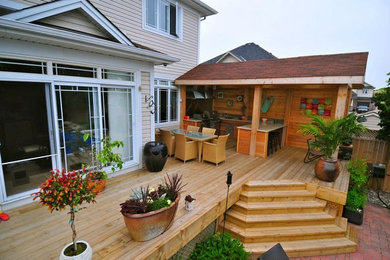 Inspiration for a mid-sized timeless backyard outdoor kitchen deck remodel in Ottawa with a roof extension