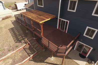 Inspiration for a large timeless backyard deck remodel in Denver with a pergola