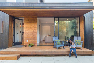 Small minimalist backyard privacy deck photo in Portland with a roof extension