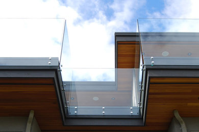 Cette photo montre une très grande terrasse arrière moderne avec une cuisine d'été et une extension de toiture.