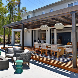 Esempio di una terrazza minimal dietro casa con una pergola e un focolare