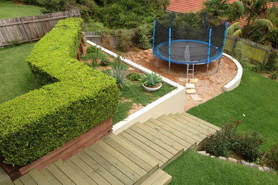 Diseño de terraza actual de tamaño medio en patio trasero con pérgola