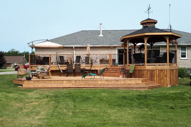 Inspiration for a large farmhouse backyard deck remodel with no cover