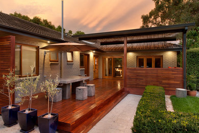 This is an example of a small contemporary back terrace in Canberra - Queanbeyan with a roof extension.