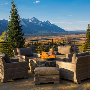 Inspiration for a large rustic backyard deck remodel in Other with a fire pit and no cover