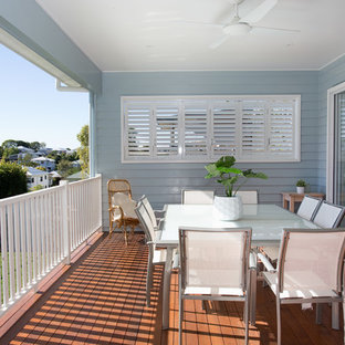 This is an example of a large contemporary backyard deck in Brisbane with a roof extension.