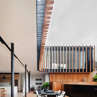 Immagine di un'ampia terrazza contemporanea con un tetto a sbalzo