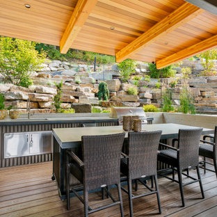 Inspiration for a large contemporary backyard outdoor kitchen deck remodel in Seattle with a roof extension