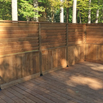 Large Brown Treated Wood Deck with Black Metal Spindle Railings & Privacy Walls