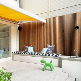 Esempio di una terrazza design di medie dimensioni e dietro casa con un parasole