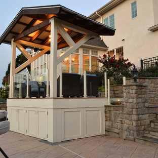 Exemple d'une grande terrasse arrière moderne avec une pergola et jupe de finition.