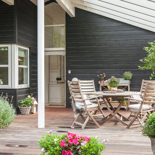 Esempio di una grande terrazza nordica dietro casa con un giardino in vaso e una pergola