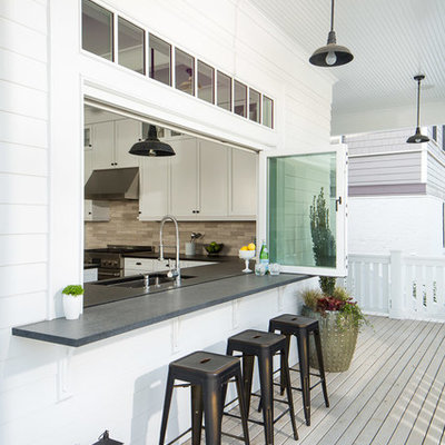 Example of a mid-sized transitional backyard deck design in Seattle with a roof extension