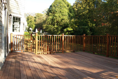 Example of a mid-sized backyard deck design in New York with no cover