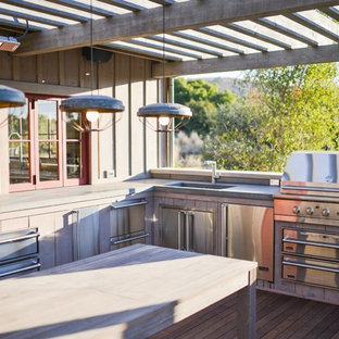 Ispirazione per una terrazza country con una pergola