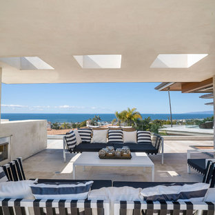 Large beach style rooftop rooftop deck photo in Los Angeles with a fireplace and a roof extension