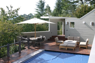 На фото: терраса среднего размера на заднем дворе в стиле модернизм с местом для костра без защиты от солнца