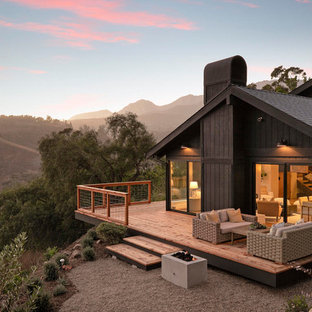 Example of a mid-sized country side yard deck design in Santa Barbara with a fire pit and no cover