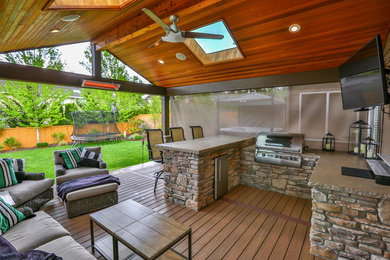 Example of a large classic backyard outdoor kitchen deck design in Seattle with a roof extension