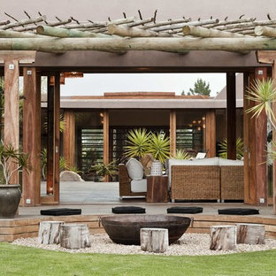 Example of a large trendy courtyard deck design in Other with a pergola
