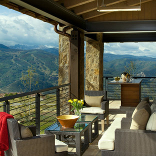 Inspiration pour une terrasse arrière chalet de taille moyenne avec une extension de toiture.