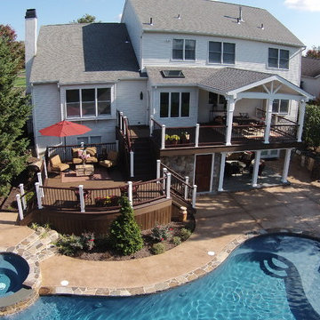 Multi-level deck design with outdoor kitchen and pool.