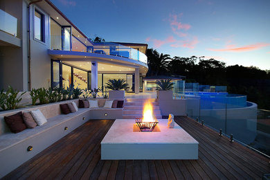 Große Moderne Terrasse hinter dem Haus mit Feuerstelle und Beleuchtung in Sydney