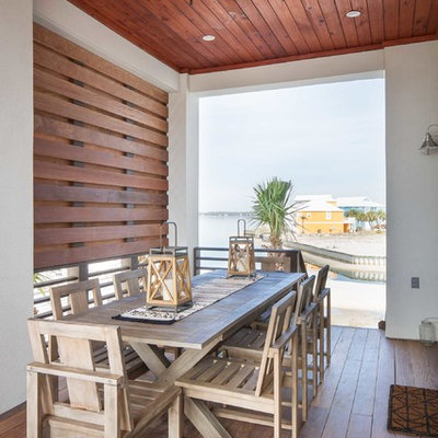 Large beach style side yard deck photo in Other with a roof extension