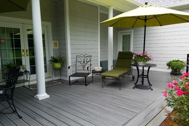 Large elegant backyard deck photo in Other with a roof extension