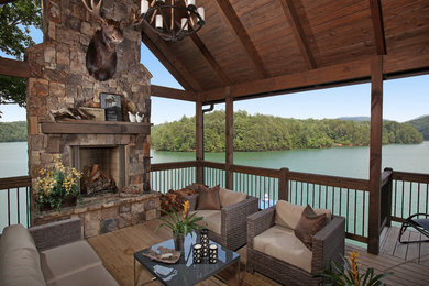 Example of a mountain style deck design in Atlanta with a fire pit and a roof extension