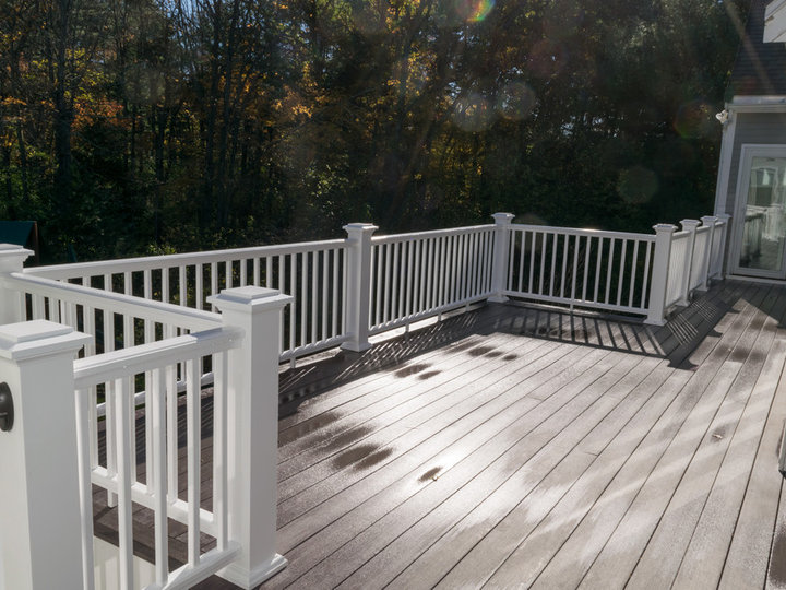 Large elegant backyard deck photo with a roof extension