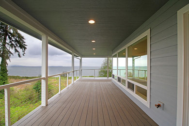 Large beach style backyard deck photo in Seattle with a roof extension