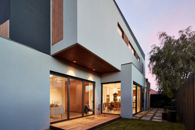 Cette image montre une terrasse latérale minimaliste avec une extension de toiture.