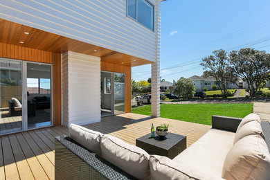 Imagen de terraza moderna grande en patio lateral y anexo de casas