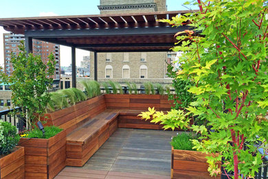 Trendy rooftop rooftop deck container garden photo in New York with a pergola