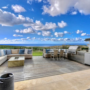 Idee per una grande terrazza costiera dietro casa con un focolare e nessuna copertura
