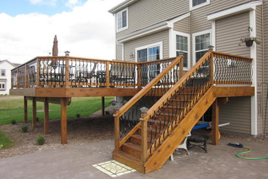 Example of a mid-sized transitional backyard deck design in Milwaukee with no cover