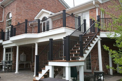 Diseño de terraza clásica grande en patio trasero y anexo de casas