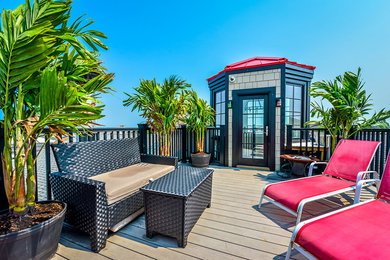 Example of a large beach style rooftop deck design in DC Metro with a fire pit and no cover