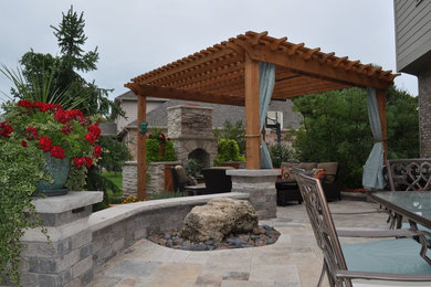 Imagen de terraza clásica de tamaño medio en patio trasero con brasero y pérgola